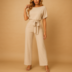 High waist jumpsuit for women named Naomi with lace-up detail, flattering fit, and flowing fabric in black, navy blue, yellow, and apricot.
